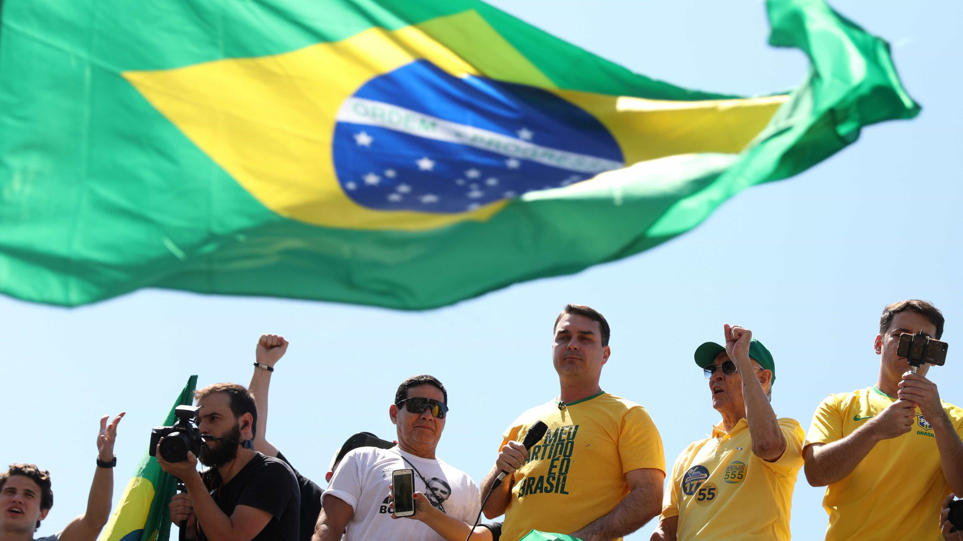 De colete, filho de Bolsonaro diz a eleitores que pai voltará em breve