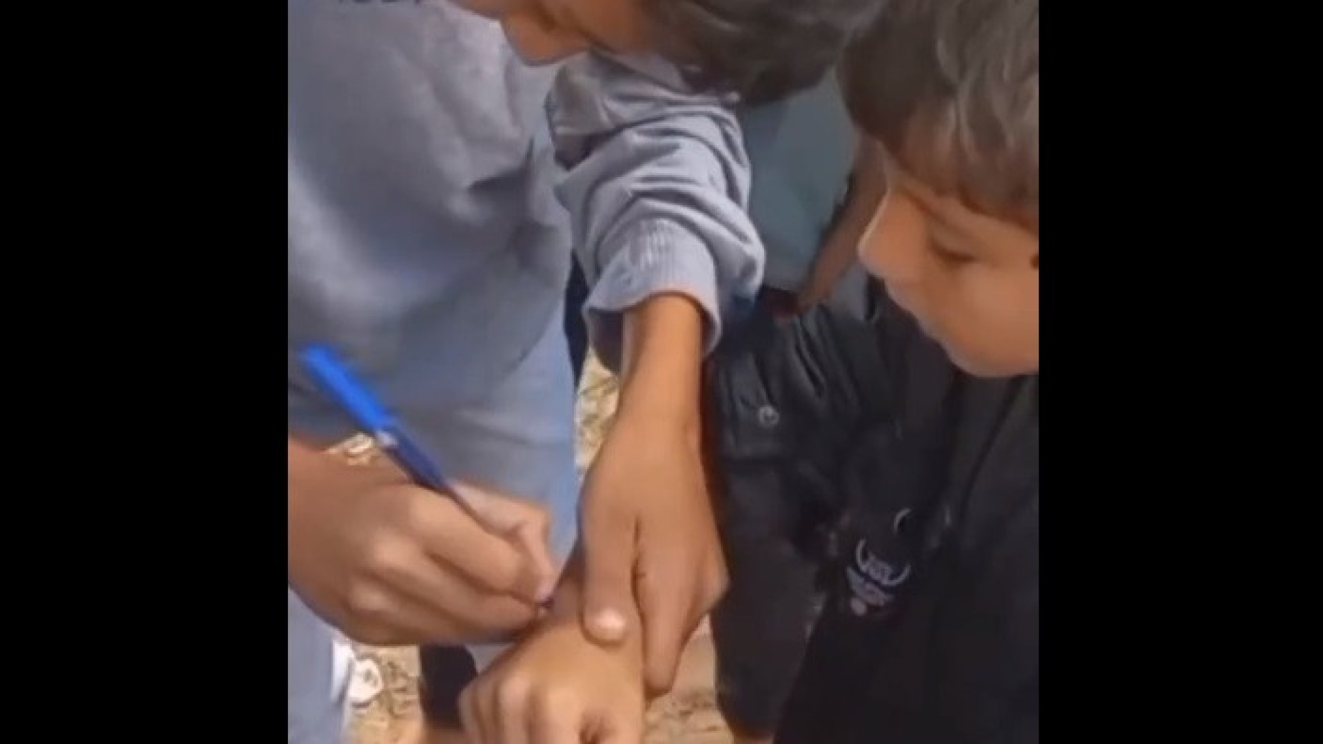 Crianças palestinas escrevem nome no braço para serem identificadas