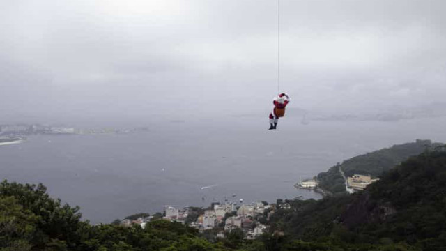 De máscara, Papai Noel chega de rapel ao Rio de Janeiro