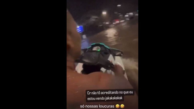 Homem pilota moto aquática em bairro alagado no Rio