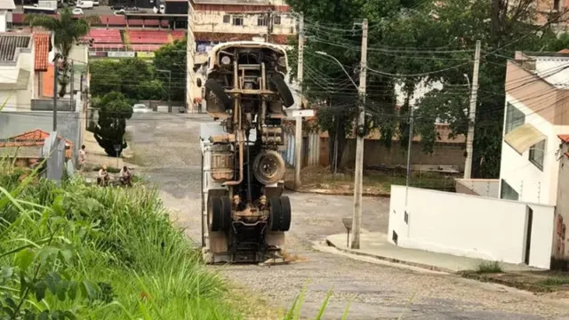 
                    Caminhão carregado de areia tomba em ladeira e fica na vertical em MG
                